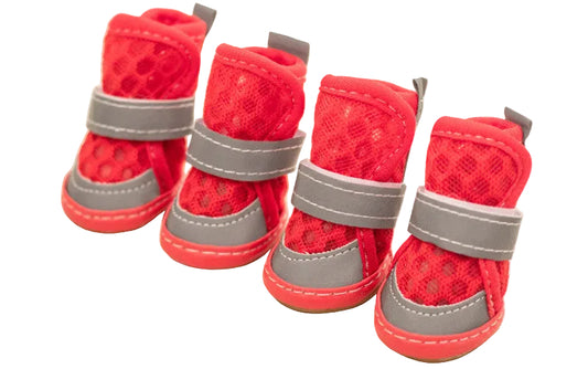 Four red pet boots with gray straps on a light wooden surface